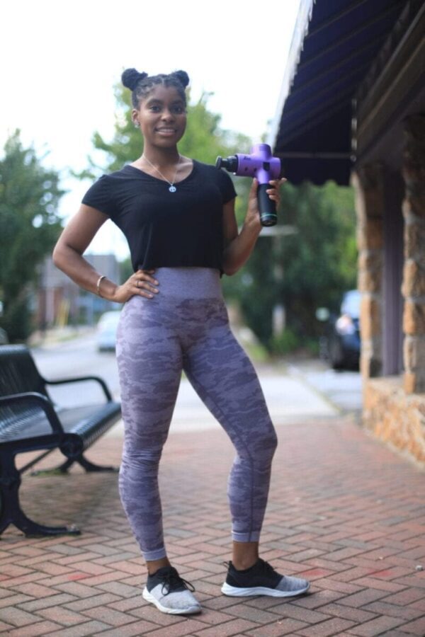 women athlete holding total massage gun