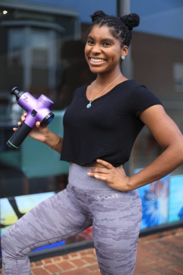 women athlete holding total massage gun